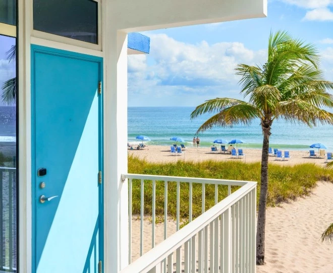 a blue door and palm trees on a beach