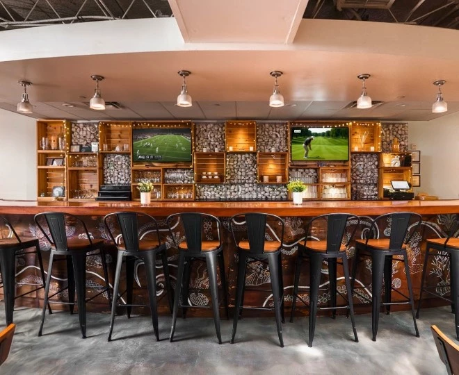 a bar with chairs and a television on the wall