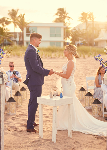 a couple getting married on the beach at sunset