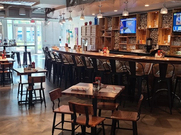 A dining area with a bar, tables, and chairs.