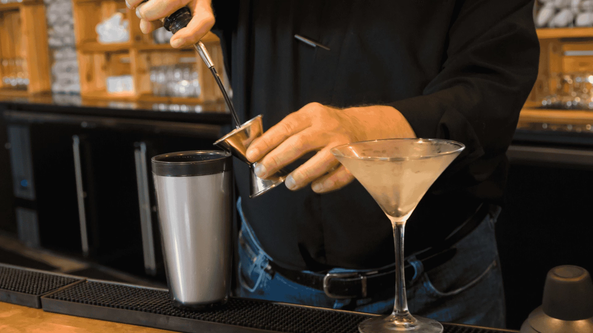 a person holding a metal cup with a metal handle