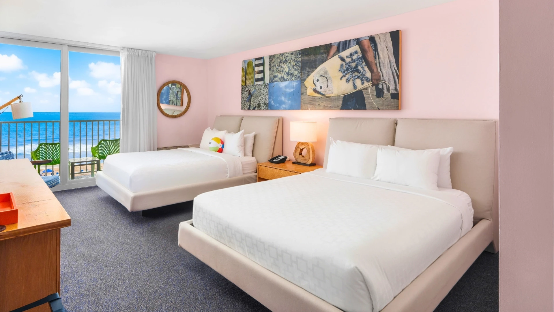 A hotel room with two beds, a balcony, and ocean view