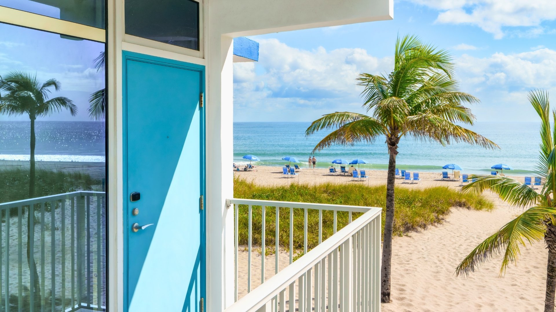 a blue door and palm trees on a beach