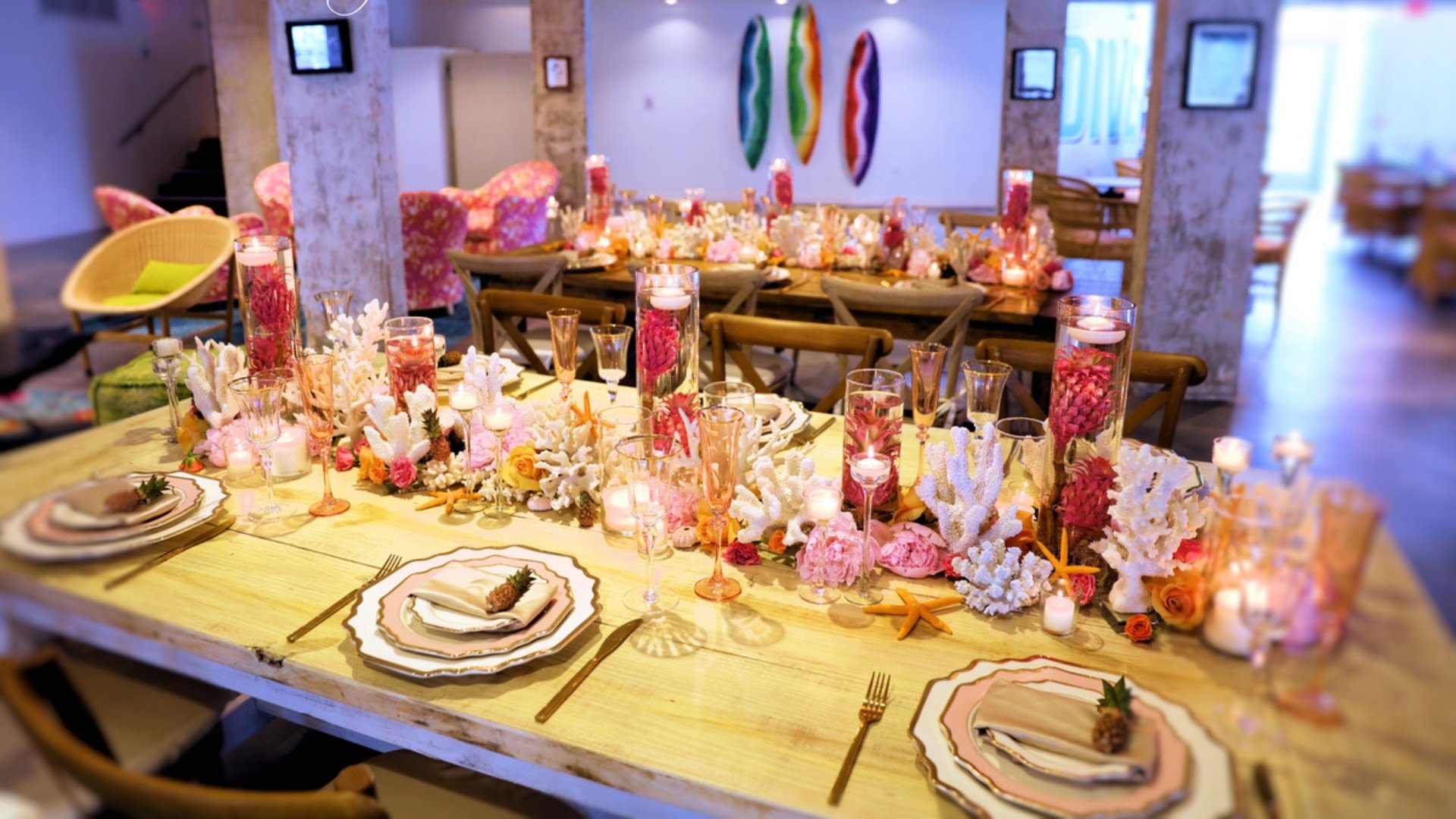 A dining table set with plates, glasses, and flowers