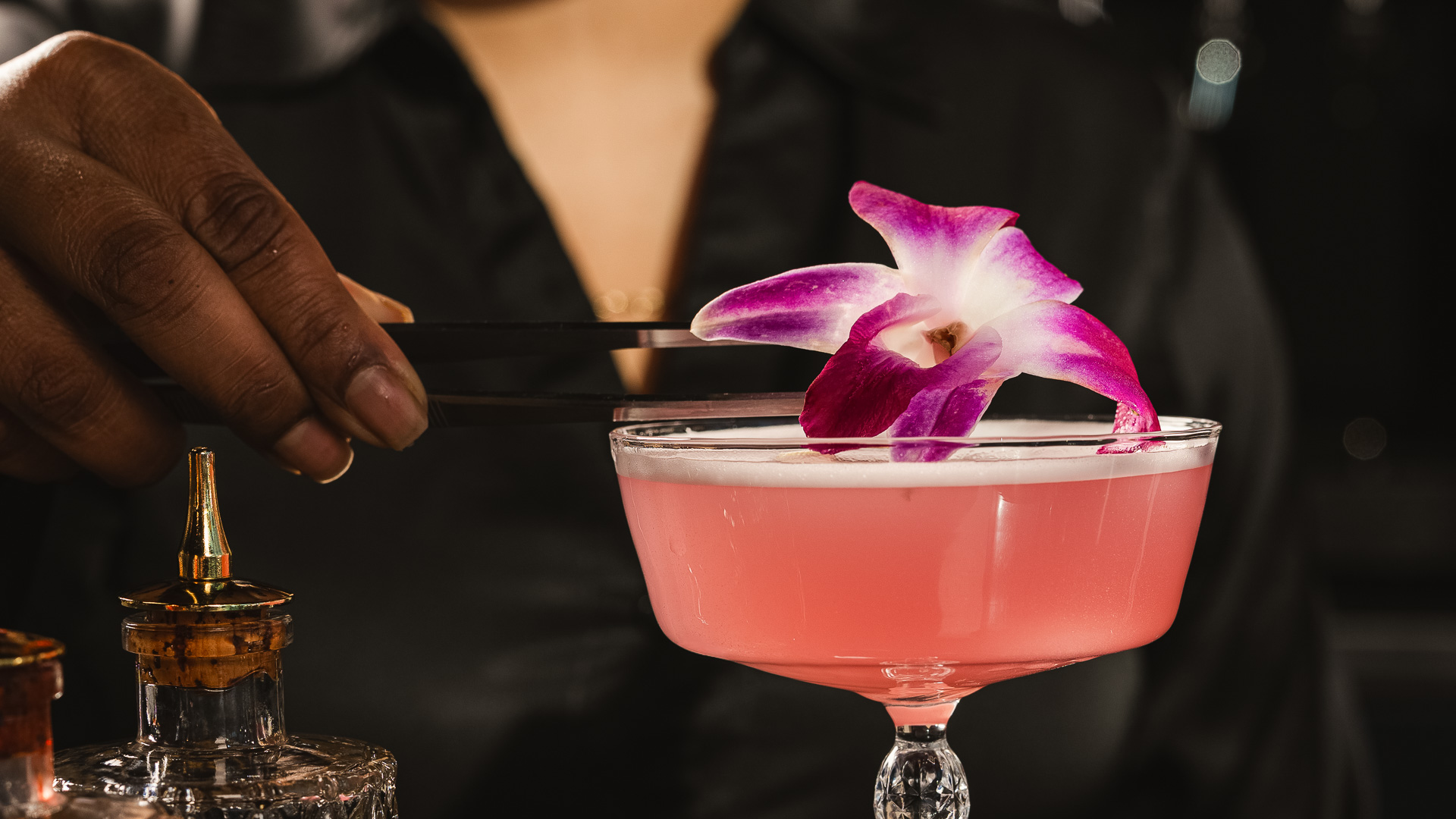 a person holding a pink drink with a flower on it