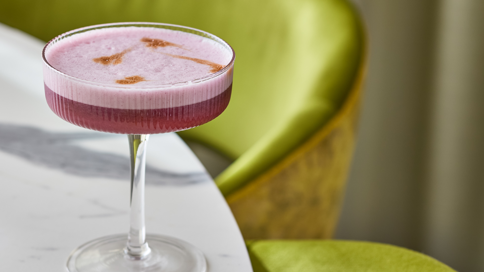 a glass with a pink drink in it