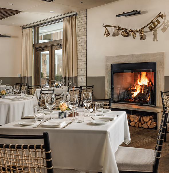 a room with tables and chairs and a fireplace