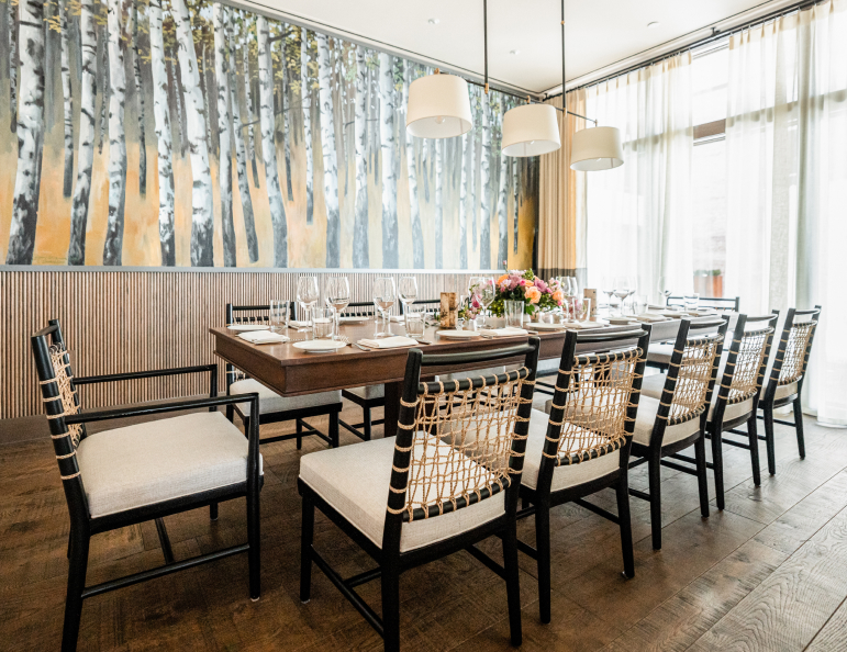 a table set up in a room with chairs and a wall of curtains