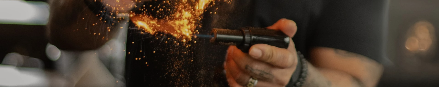 a hand holding a blowtorch