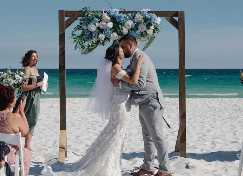 a man and woman kissing on a beach