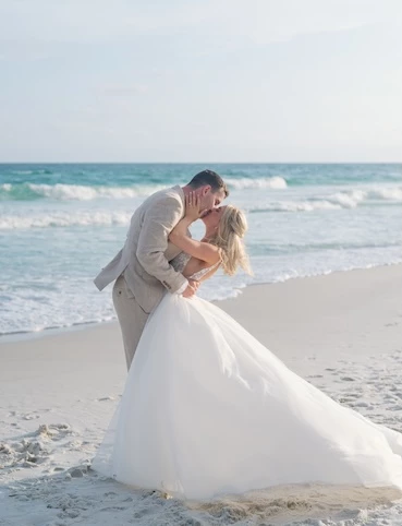 a man and woman kissing on a beach