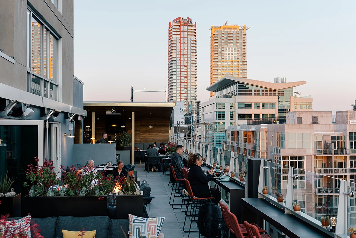 a group of people sitting at tables on a rooftop