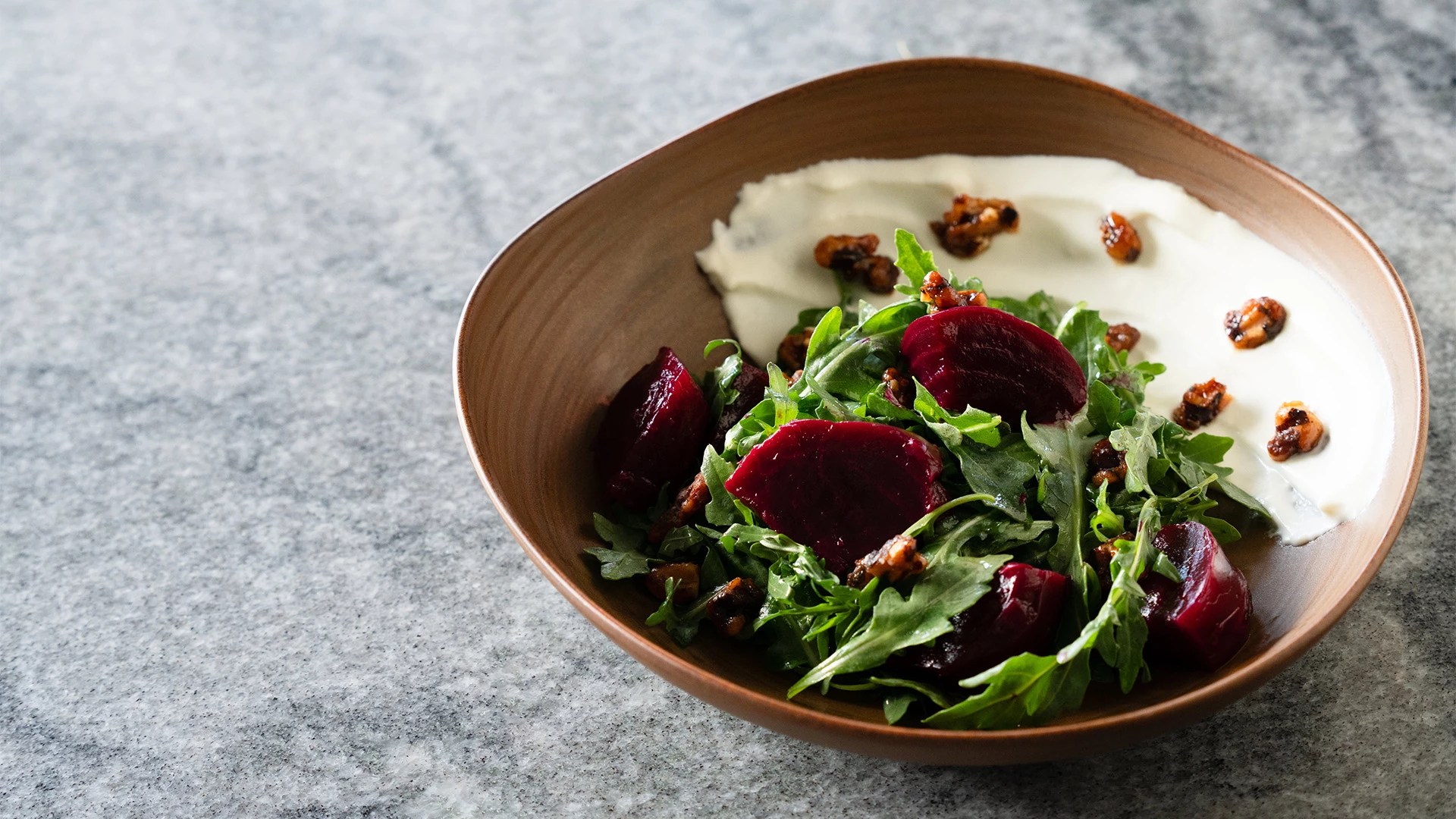 a bowl of salad with beets and nuts