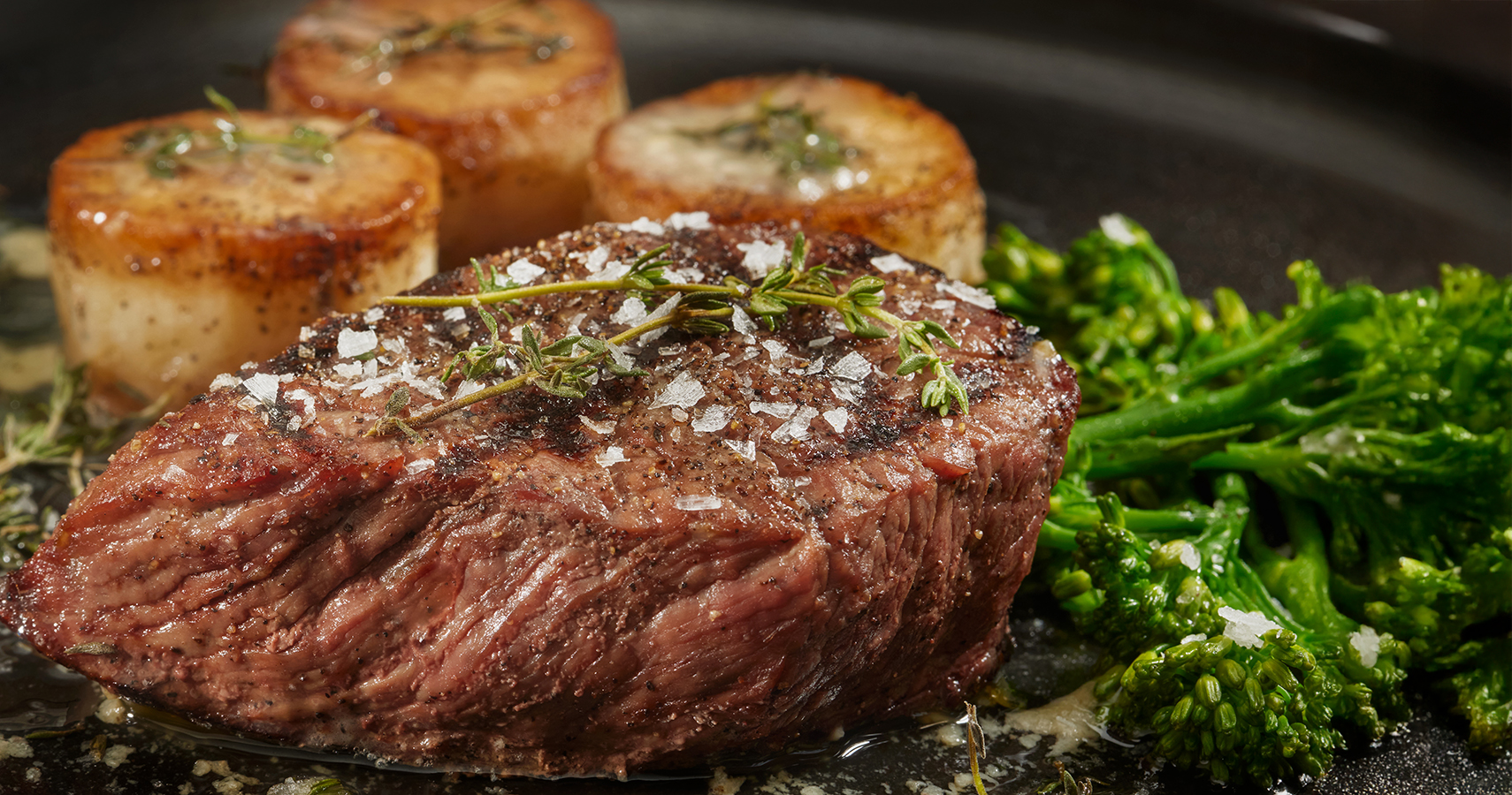 a steak and scallops on a pan