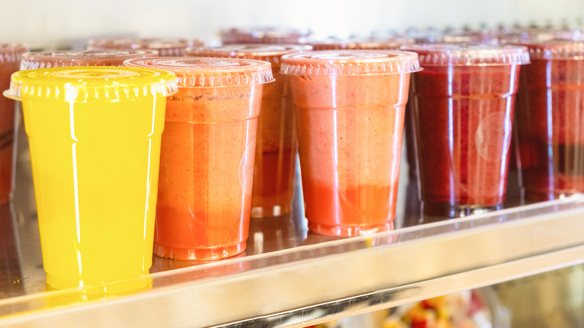 a group of plastic cups with different colored liquid in them