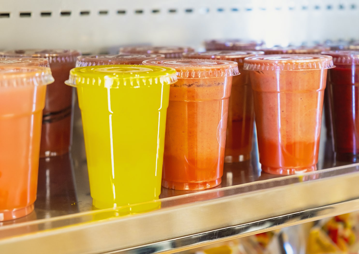 a group of plastic cups with different colored liquid in them