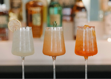 a group of drinks in wine glasses