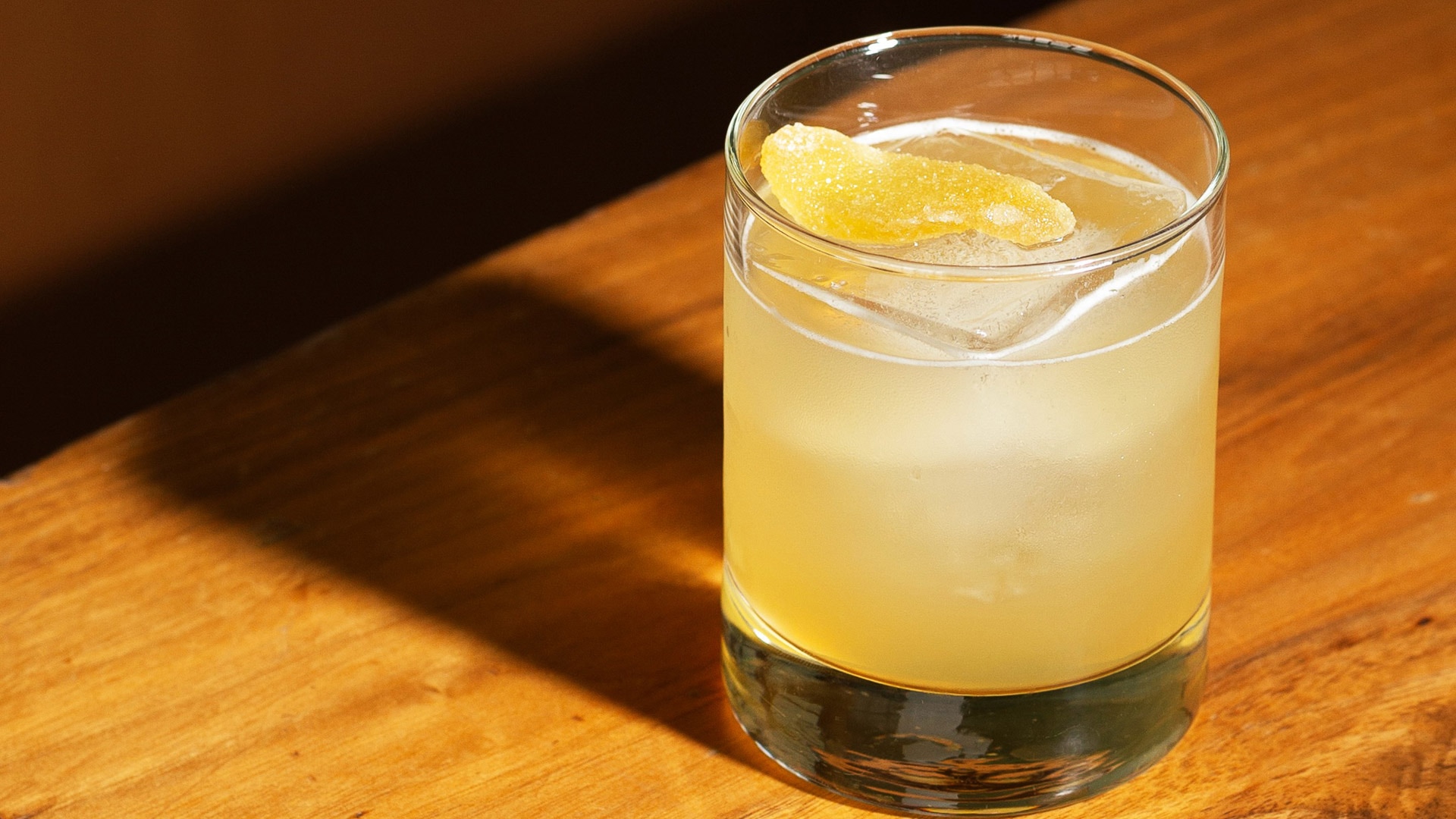 a glass of liquid with a piece of orange peel on top