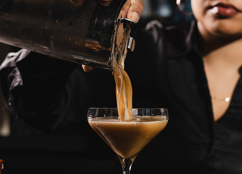 a person pouring liquid into a glass