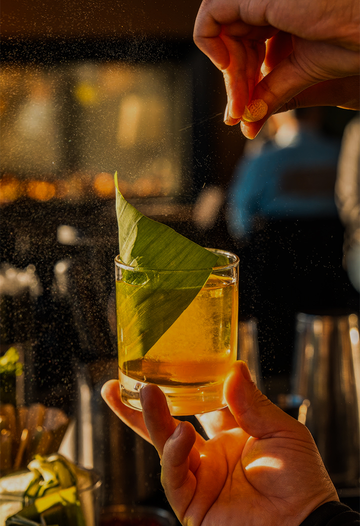 a person pouring a drink into a glass