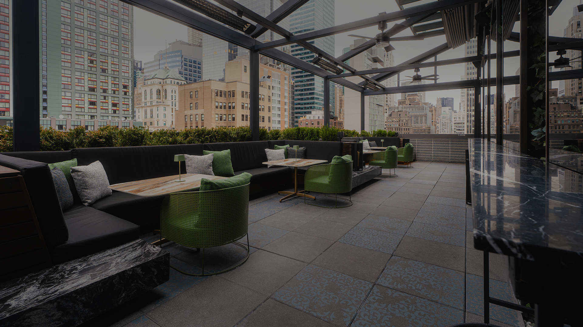 a rooftop patio with a large glass roof and tables and chairs
