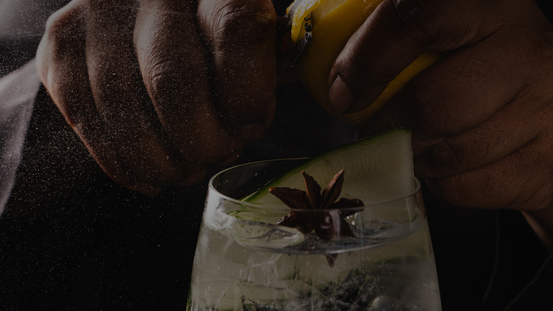 a person squeezing a lemon into a glass of water