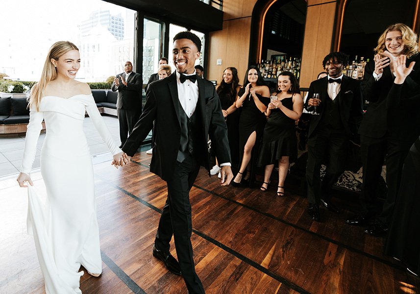 a man and woman in formal attire holding hands and dancing