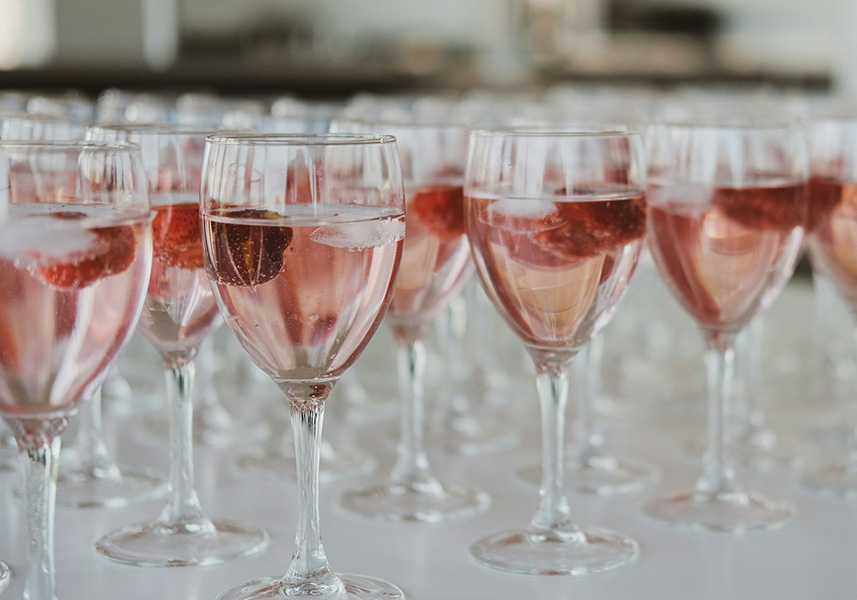 a group of glasses of pink liquid with a strawberry in it
