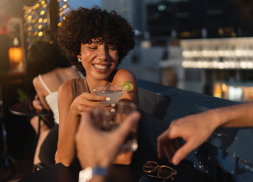 a woman smiling at a drink