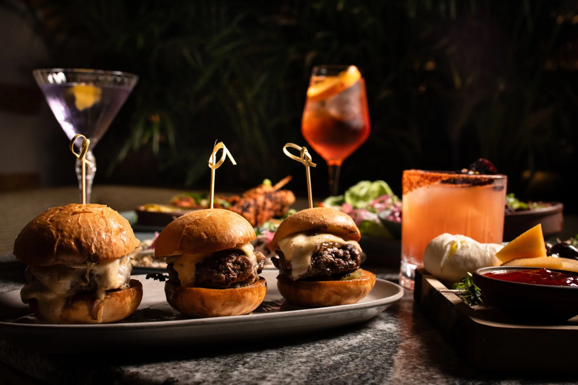 a plate of mini burgers and a drink