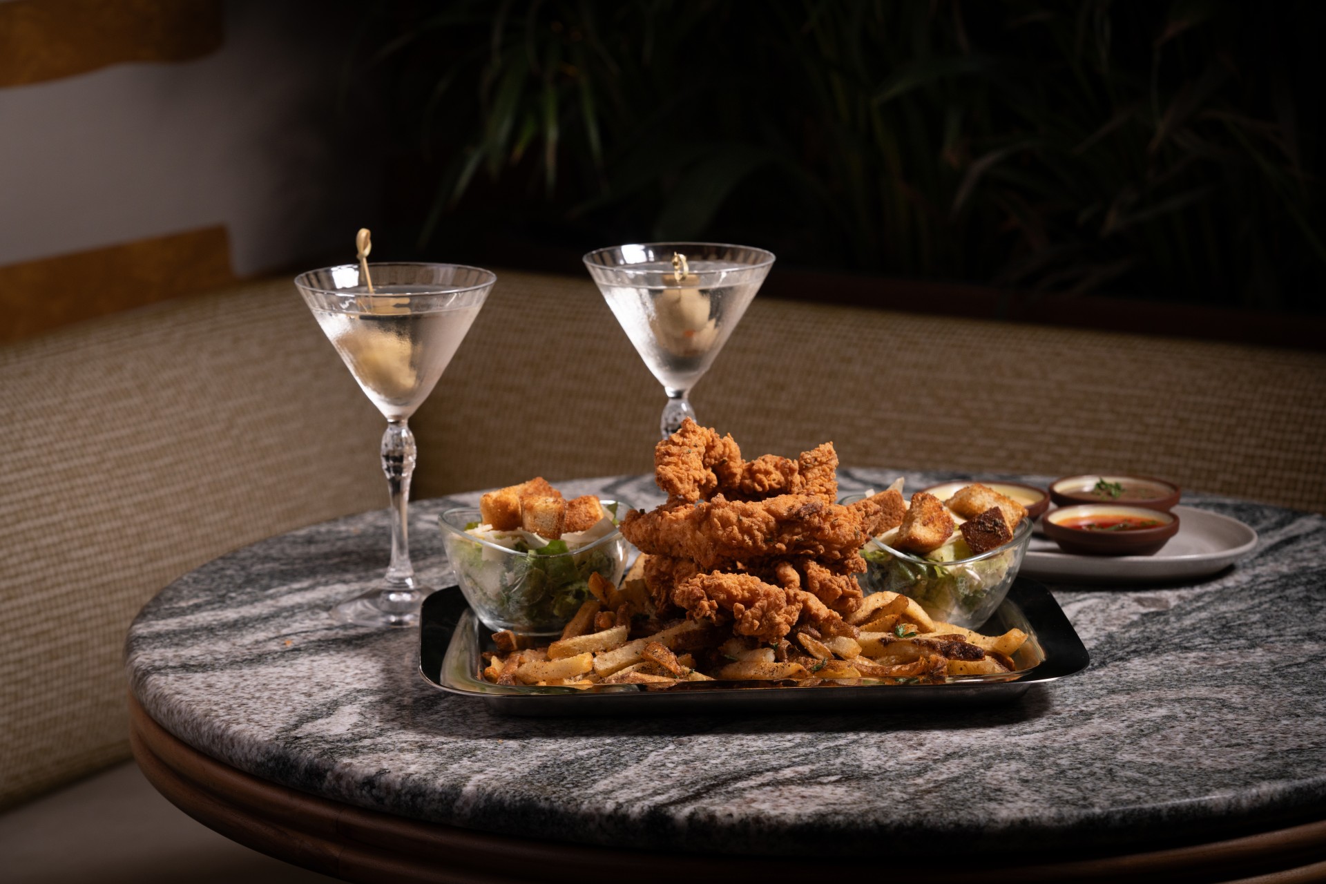 a plate of food and martini glasses on a table