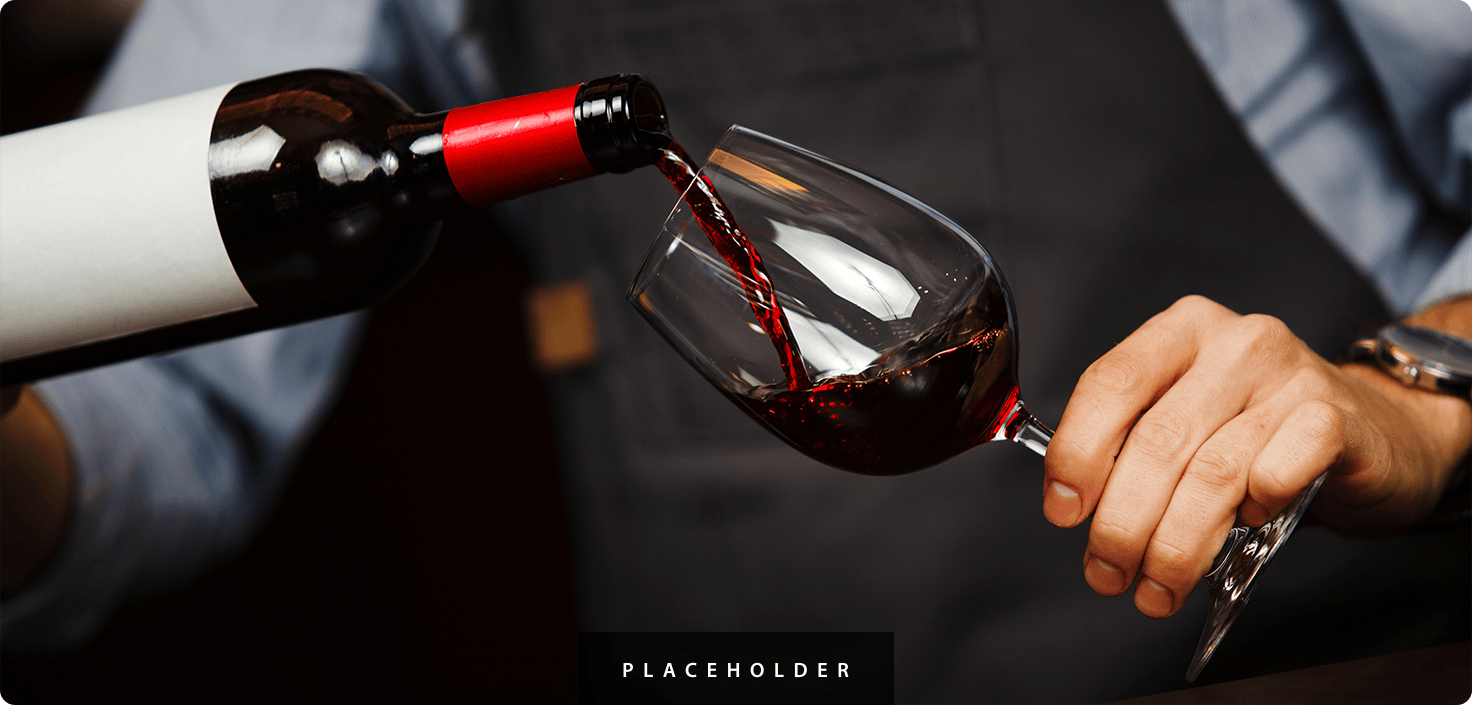 a person pouring wine into a glass