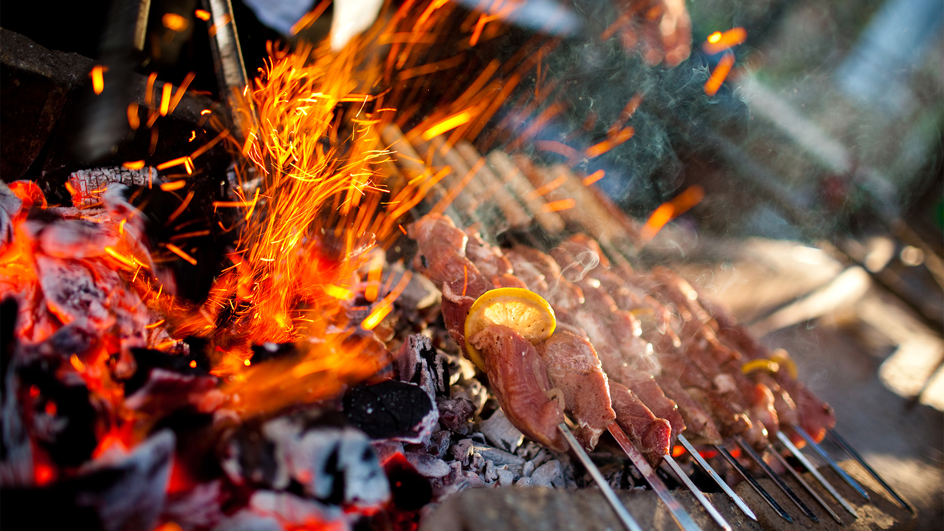 a group of meat on skewers over a fire