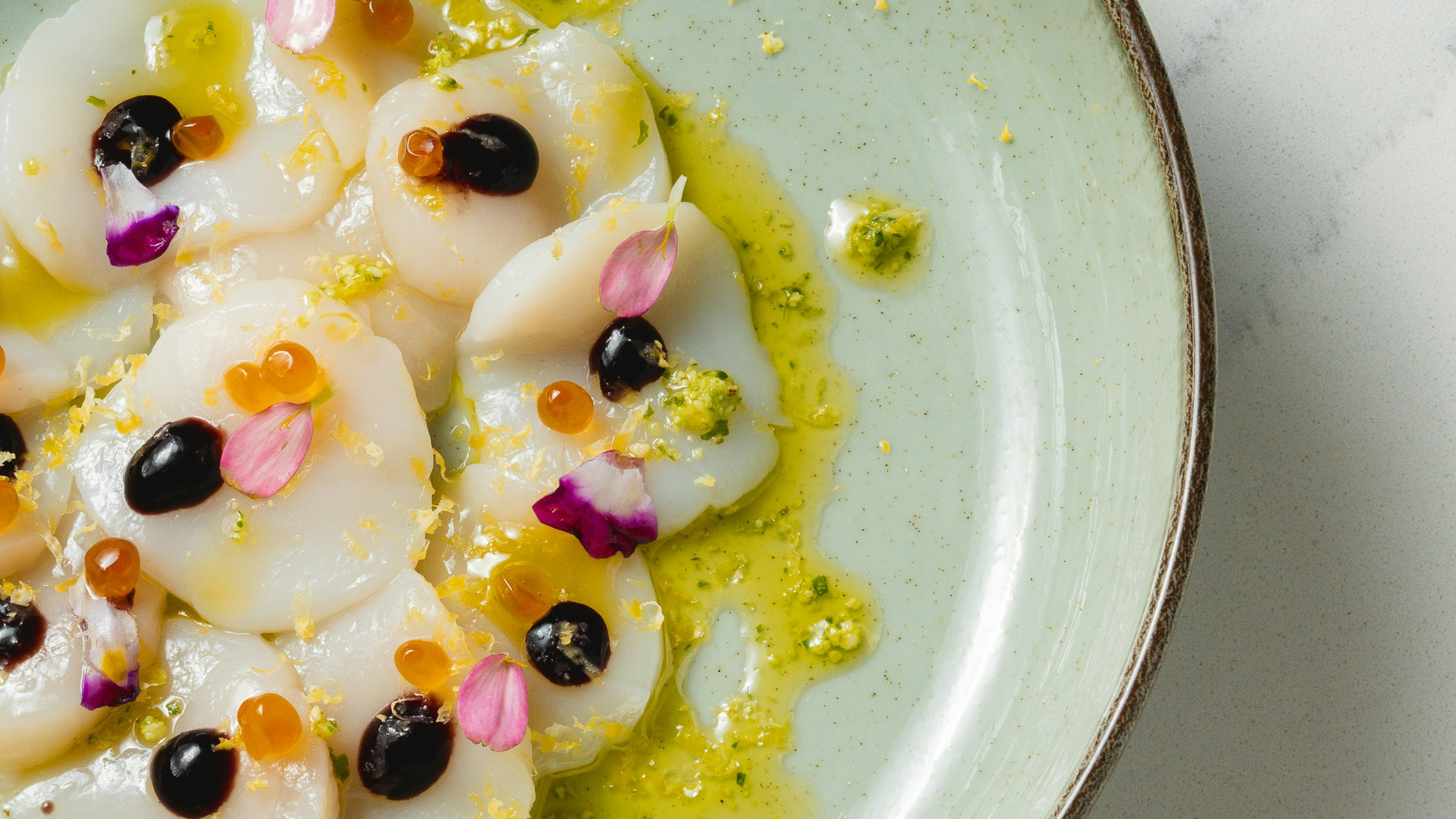 a plate of scallops with flowers on it