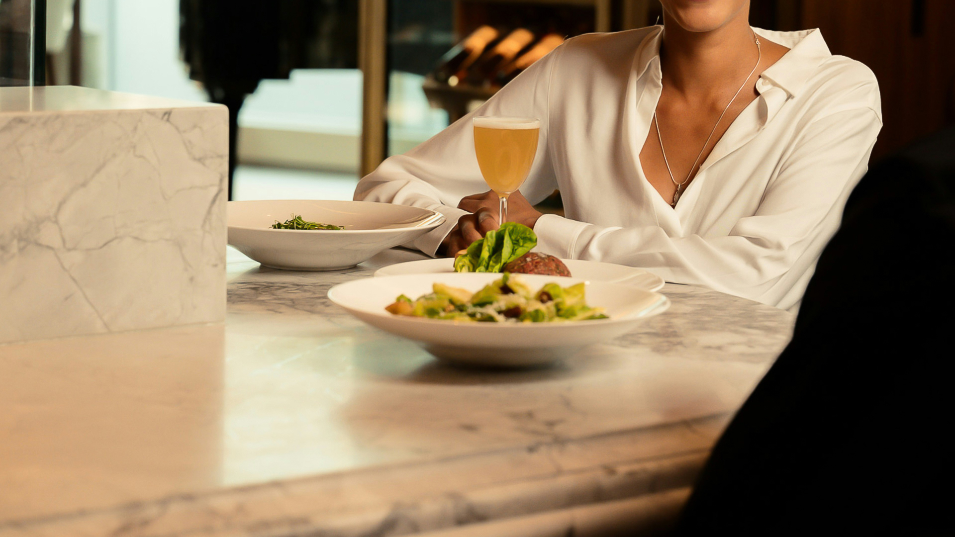 a woman sitting at a table with plates of food