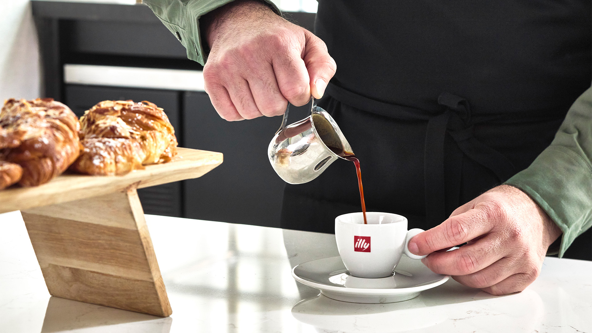 a person pouring coffee into a cup