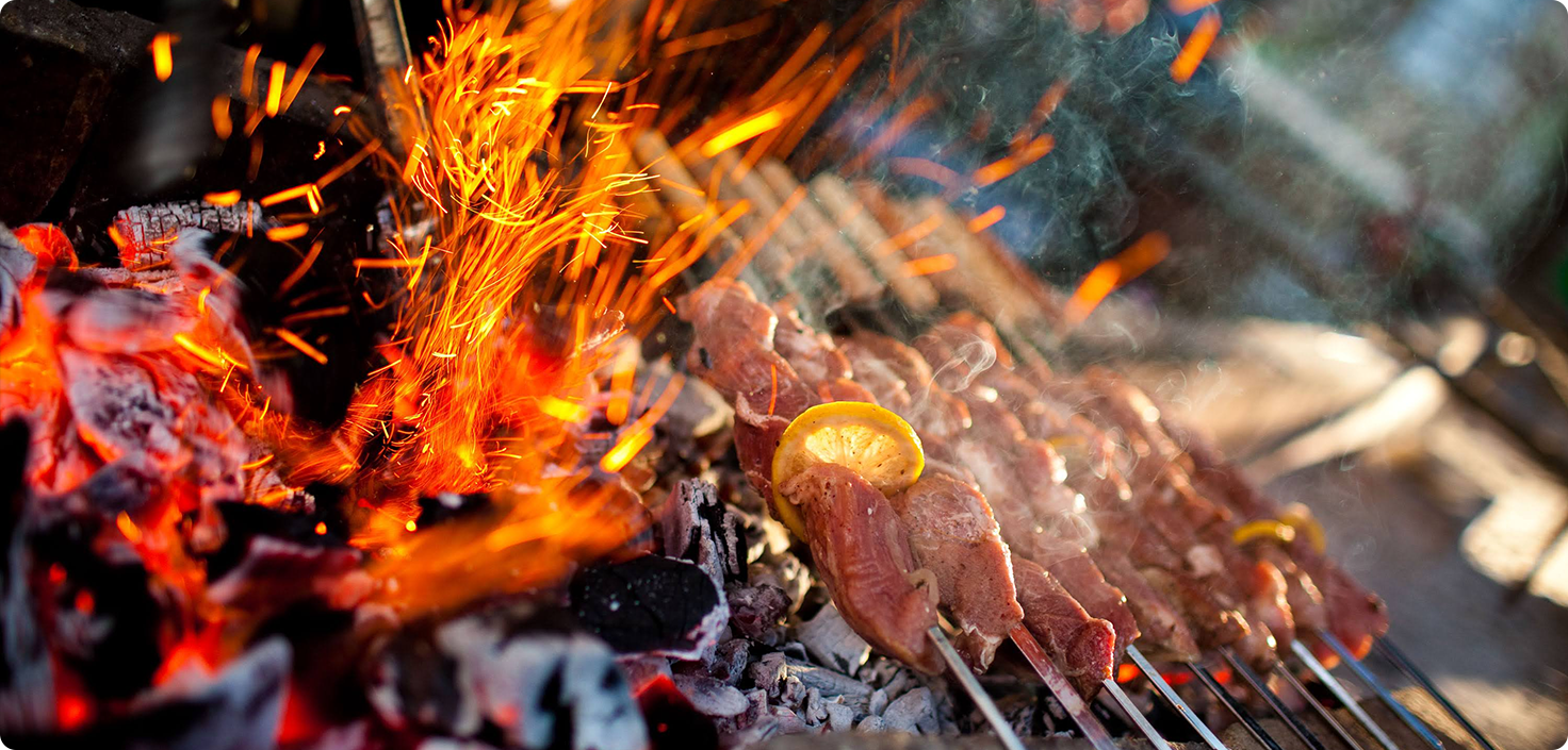 meat on skewers cooking on a fire