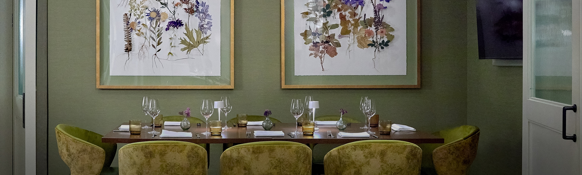 a table with wine glasses and a picture on the wall