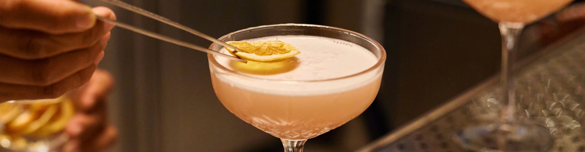 a glass with a drink and a lemon slice on it