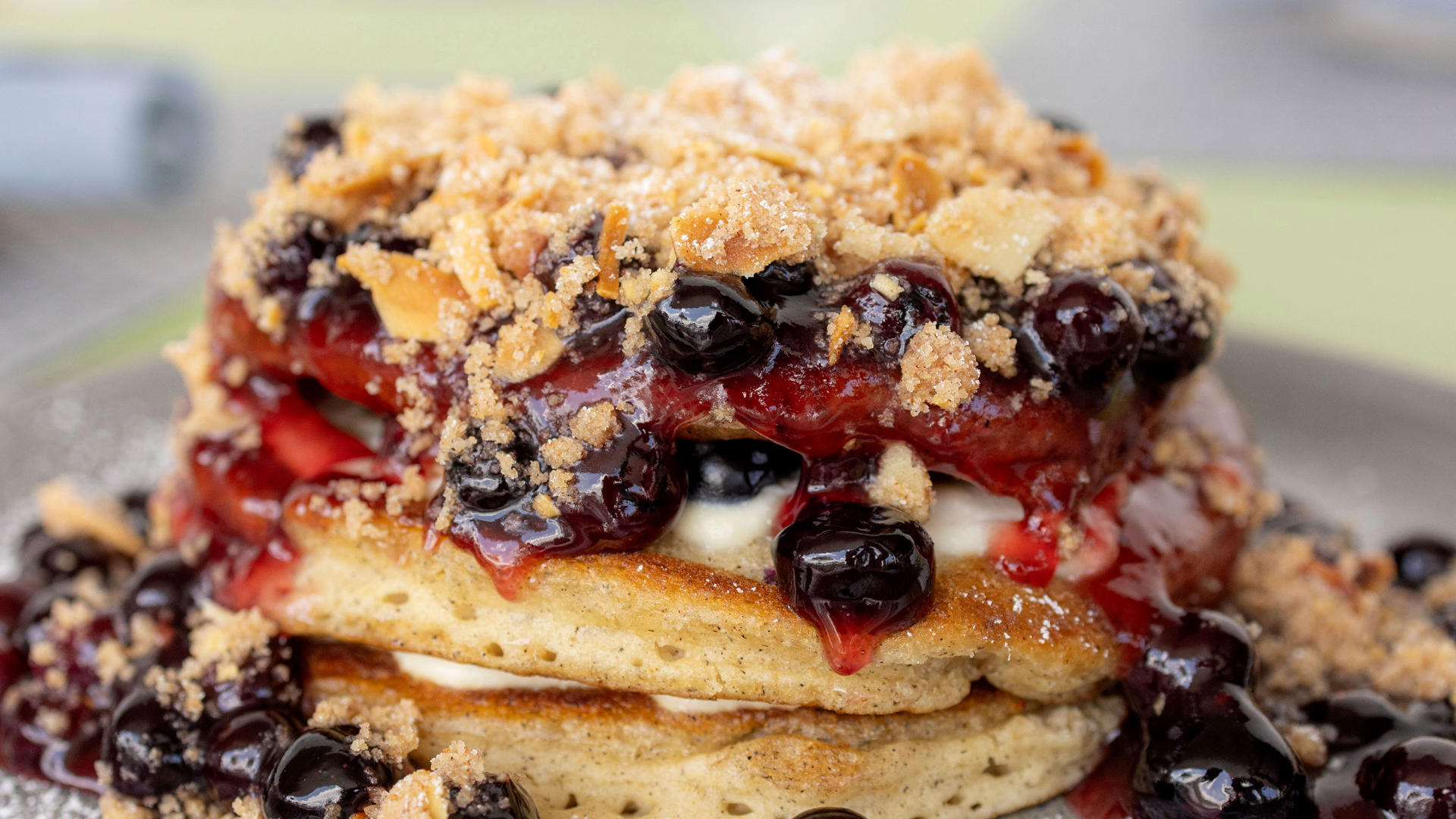 a stack of pancakes with berries and toppings