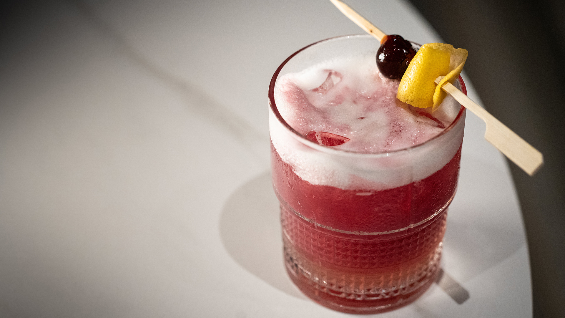 a glass with a drink and a stick on top