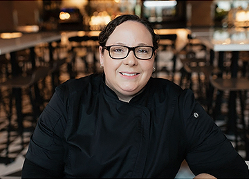 a woman wearing glasses and a black shirt