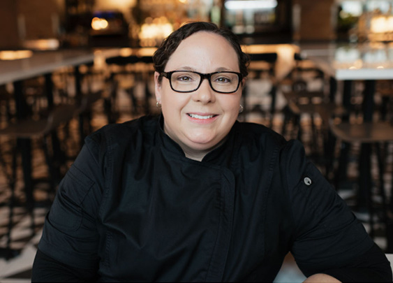a woman wearing glasses and a black jacket