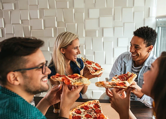 a group of people eating pizza