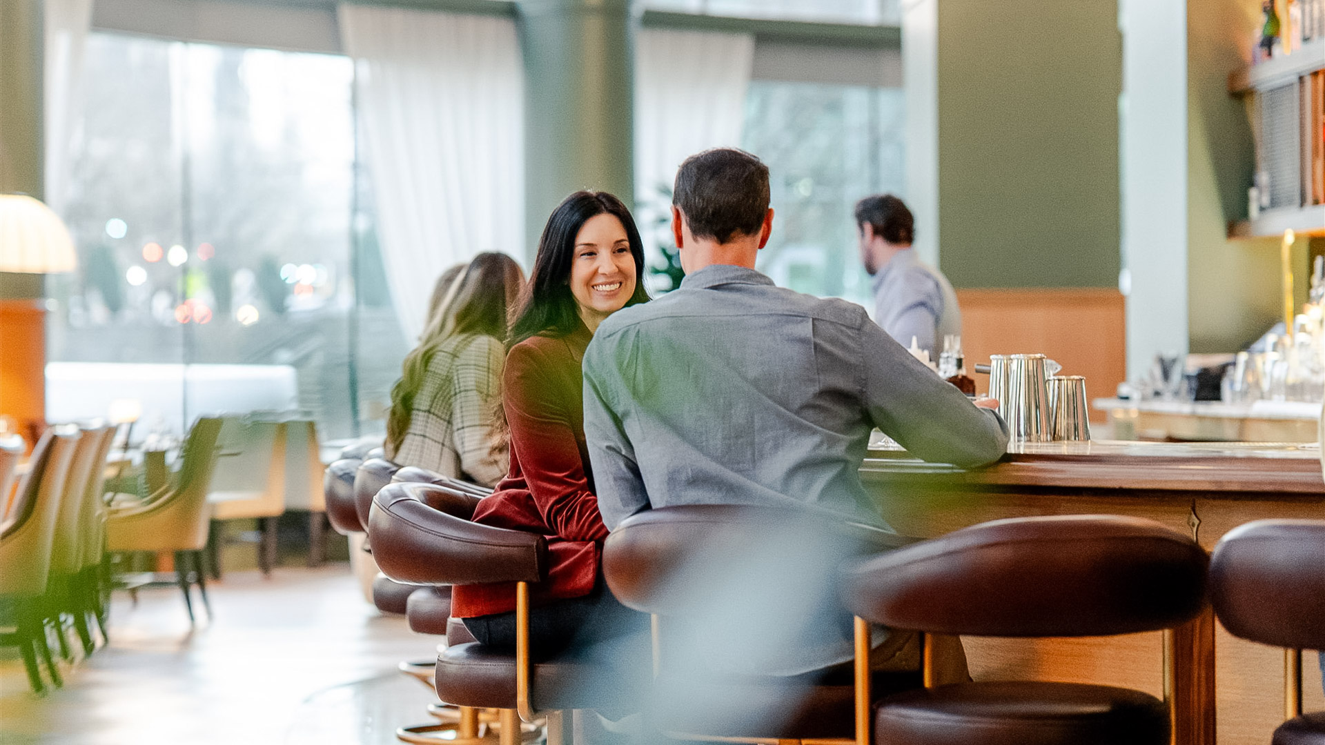 a man and woman sitting at a bar