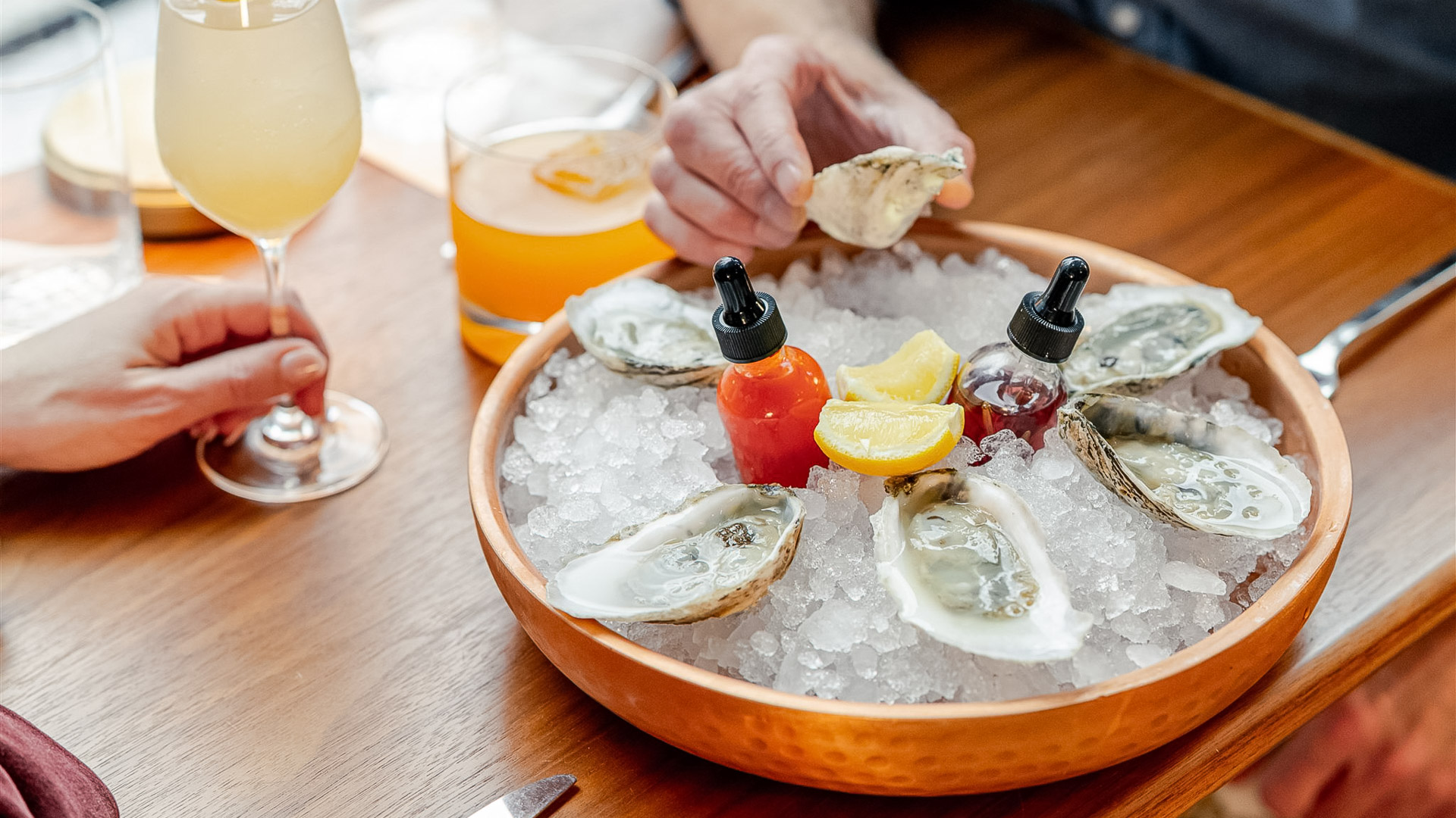 a bowl of oysters and lemons on ice