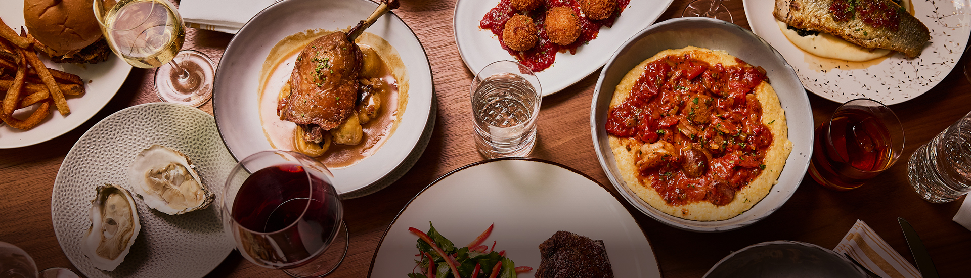 a table with plates of food and a glass of water