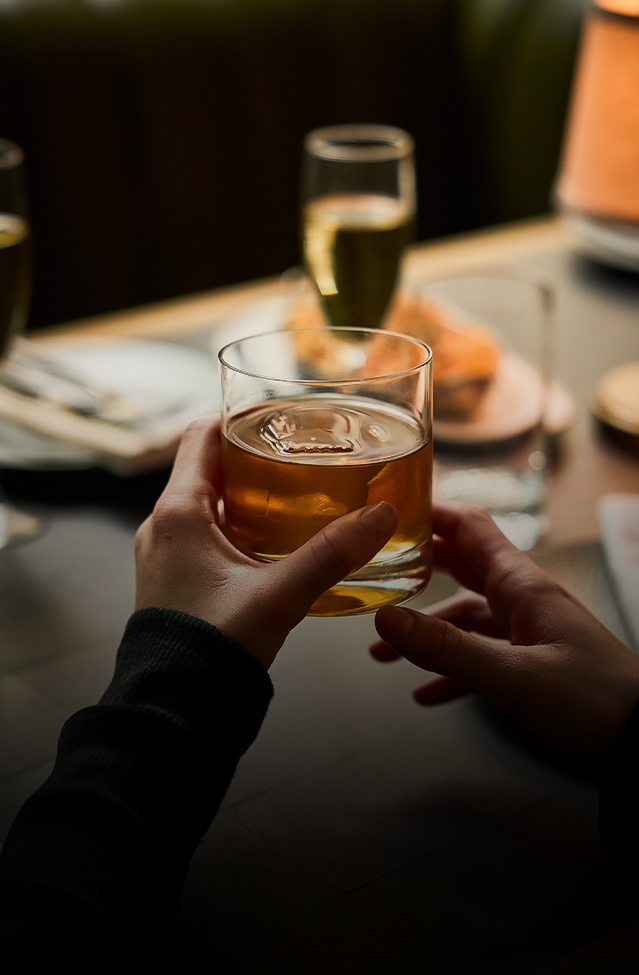 a person holding a glass of liquid