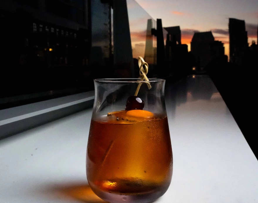 a glass with a drink and a cherry on it