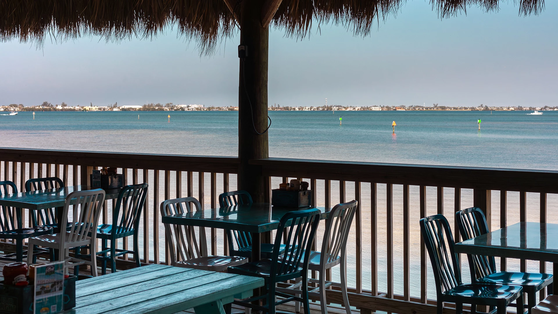 a table and chairs on a deck overlooking a body of water